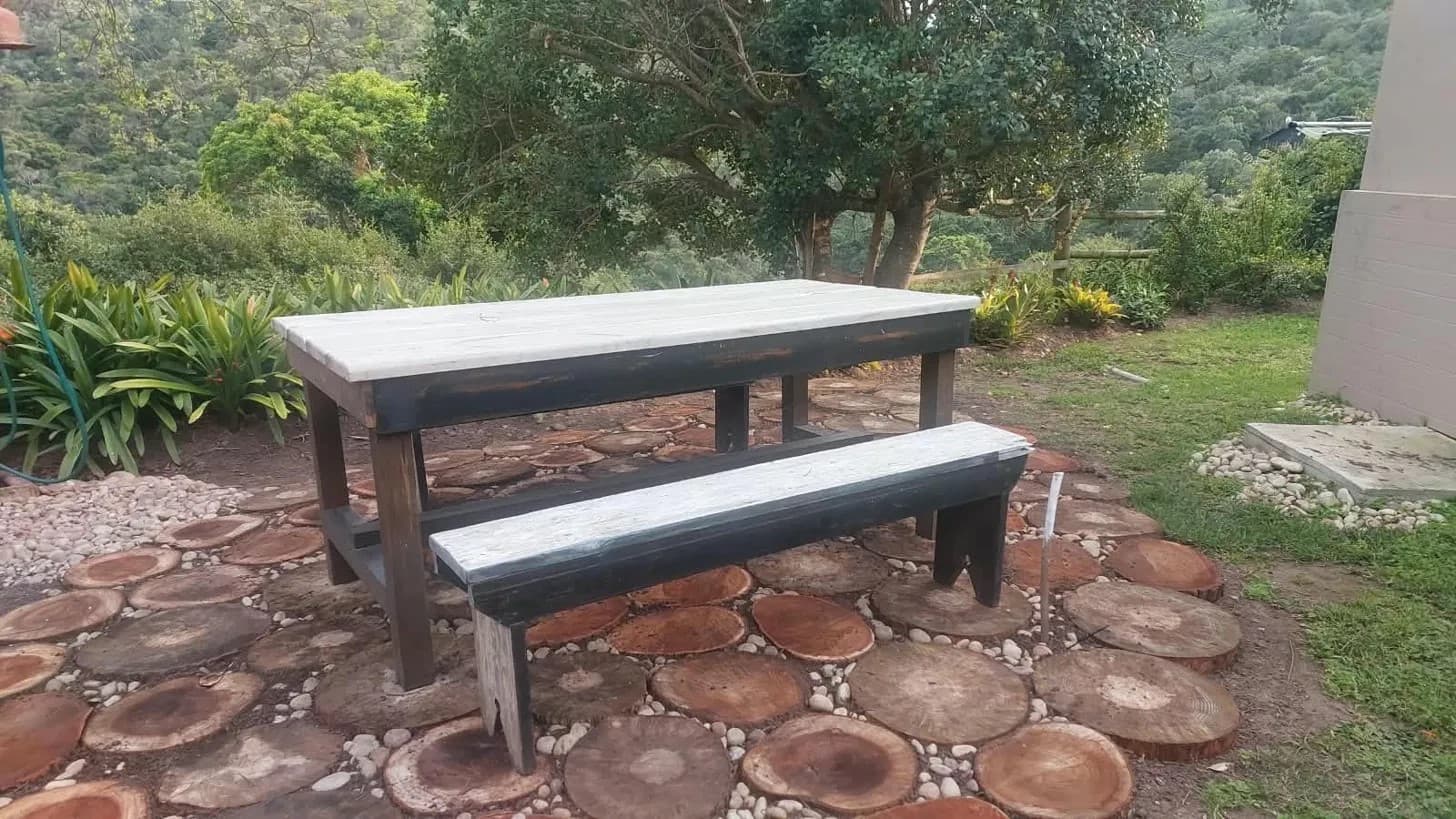 Outdoor table and benches in the forest garden at Gulls' Way